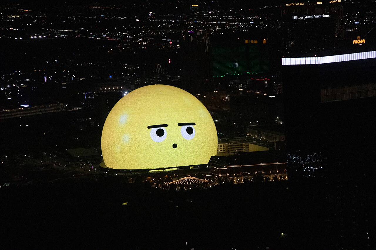 Sphere displaying a yellow face at night, seen from the STRAT tower